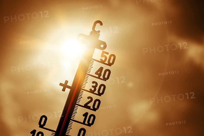 Thermometer in front of bright sun shows high temperatures, symbolic photo heat wave, photo montage +++ editorial use only