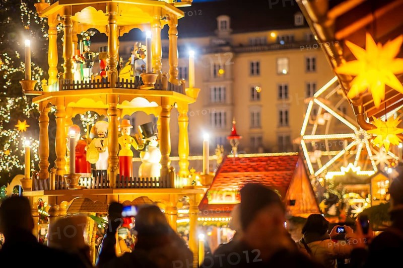Dresden's Striezelmarkt has been held in Advent since 1434, usually on the Altmarkt square, and attracts an average of around two million visitors every year. It is the oldest certified Christmas market in Germany. The European Excellent Christmas Market Association (EECMA) has recognised the Dresden Striezelmarkt 2025 as an (Excellent European Christmas Market) . Tourists taking mobile phone photos, Dresden, Saxony, Germany