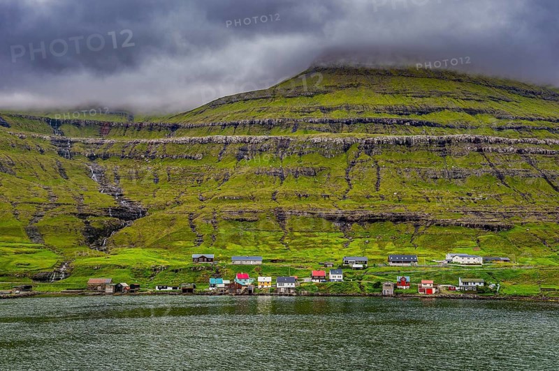 Little village on the foot of a the cliffs in Estuyroy, Faroe islands, Denmark