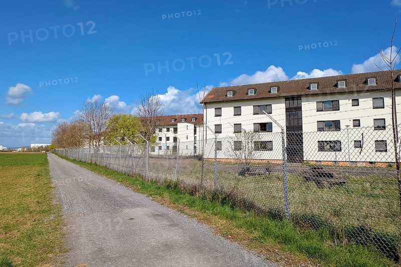 Heidelberg, Germany - April 7th 2026: Abandoned buildings in Patrick-Henry-Village Heidelberg behind barbed wire fence. Former US military housing area marked off as restricted redevelopment site