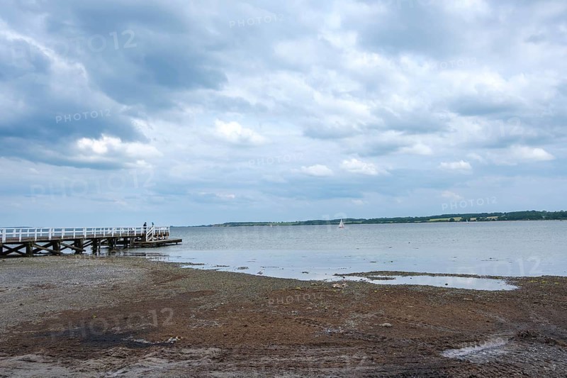 A long jetty juts into the sea while clouds gather over the sky, Hohwacht, Schleswig-Holstein, Germany
