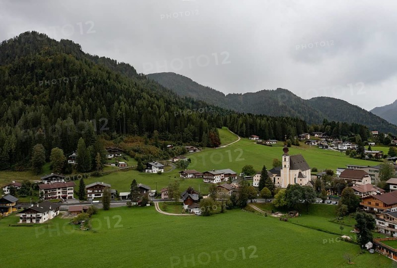 Drone shot, view of village with parish church, Waidring, Pillerseetal, Tyrol, Austria