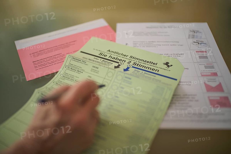 Voting, woman holding ballpoint pen, fills out ballot papers, votes, absentee ballot, official postal ballot documents, envelope, ballot envelope, instructions, election, parliamentary election, 2026 state election, Stuttgart, Baden-Württemberg, Germany