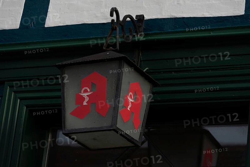 A lantern with the symbol of the pharmacies hangs on a half-timbered house, Plau am See, Mecklenburg-Vorpommern, Germany
