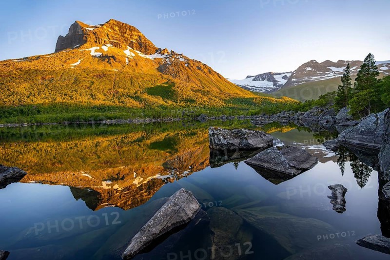 Picturesque mountain landscape in the Innerdalen high valley, mountain peaks reflected in Lake Innerdalsvatna, in the evening light at sunset, Trollheimen Mountain Area, Sunndal, Møre og Romsdal, Norway