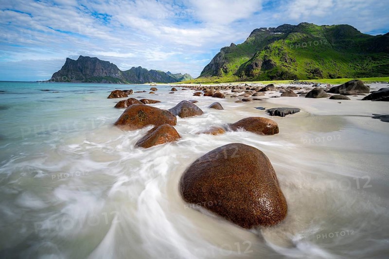 Rocks on Uttakleiv sandy beach, coast and blue sea, long exposure, rocky mountain peaks, Vestvågøya, Lofoten, Nordland, Norway