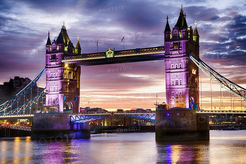 Tower Bridge's Neo-Gothic towers glowing purple over the Thames at dusk, London, United Kingdom