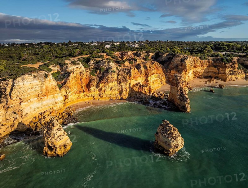 Aerial view of Praia da Marinha beach in Algarve, Portugal, with ocean cliffs, sea stacks and open shoreline patterns