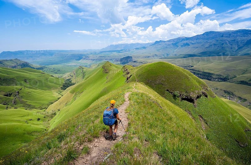 Female hiker on the hiking trail to Cathedral Peak, Green Mountains and Hills, Drakensberg Mountains, KwaZulu-Natal, South Africa