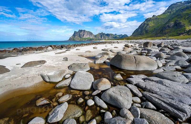 Coast and mountains, stones on the sandy beach of Uttakleiv, Vestvågøya, Lofoten, Nordland, Norway