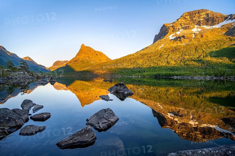 Picturesque mountain landscape with peaks in the Innerdalen high valley, mountain peaks reflected in Lake Innerdalsvatna, in the evening light at sunset, Trollheimen Mountain Area, Sunndal, Møre og Romsdal, Norway