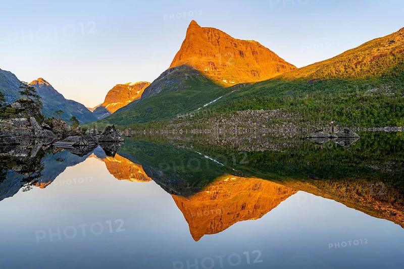 Picturesque mountain landscape in the Innerdalen high valley with Innerdalstårnet peak, mountain peaks reflected in Lake Innerdalsvatna, in the evening light at sunset, Trollheimen Mountain Area, Sunndal, Møre og Romsdal, Norway