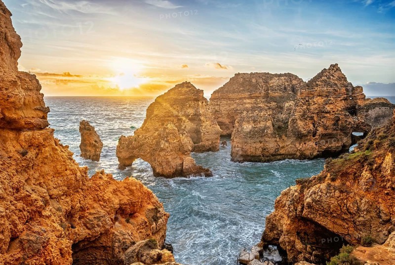 Ponte da Piedade in Lagos, Algarve, Portugal, at sunrise with Atlantic ocean, sea stacks, limestone cliffs, and a visible sea arch