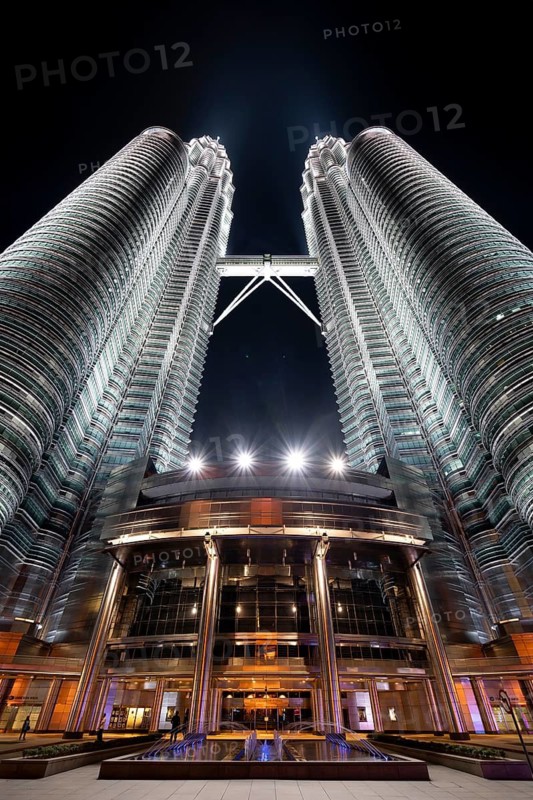 Petronas Towers, KLCC Twin Towers, interlinked 88-storey supertall twin skyscrapers illuminated at night in capital city Kuala Lumpur, Malaysia