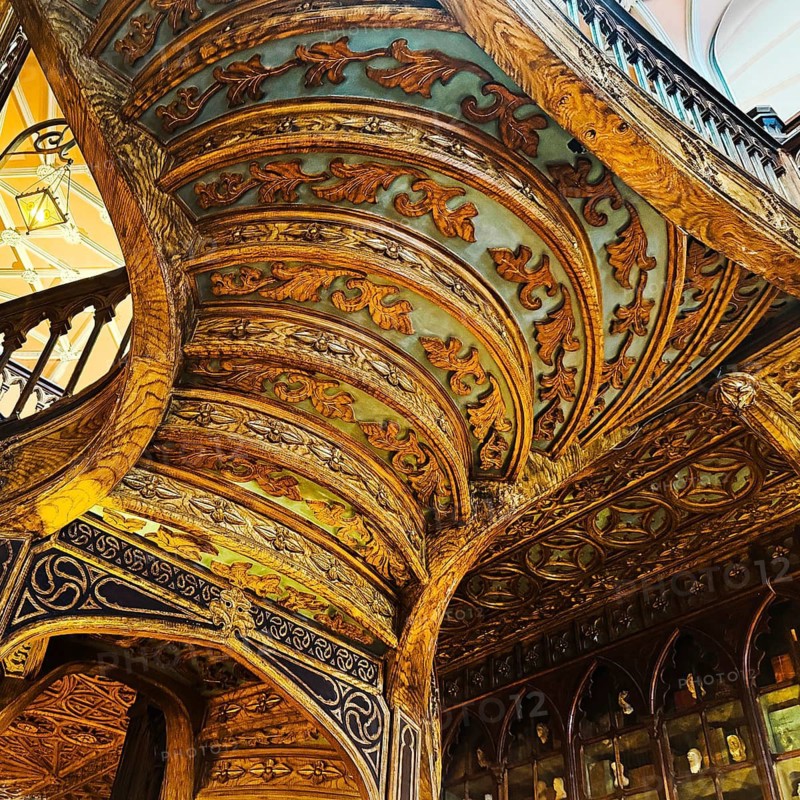Livraria Lello, interior view of the Lello bookstore with rich decorations of the curved wooden staircase from below, Porto, Portugal