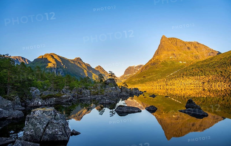 Picturesque mountain landscape with Innerdalstårnet peak in Innerdalen high valley, mountain peaks reflected in Lake Innerdalsvatna, Rollheimen Mountain Area, Sunndal, Møre og Romsdal, Norway