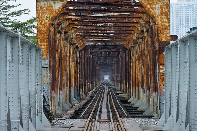 A train, locomotive, of the Vietnamese State Railways crosses the Long Bien railway bridge over the Red River, Hanoi, Ha Noi province, Vietnam
