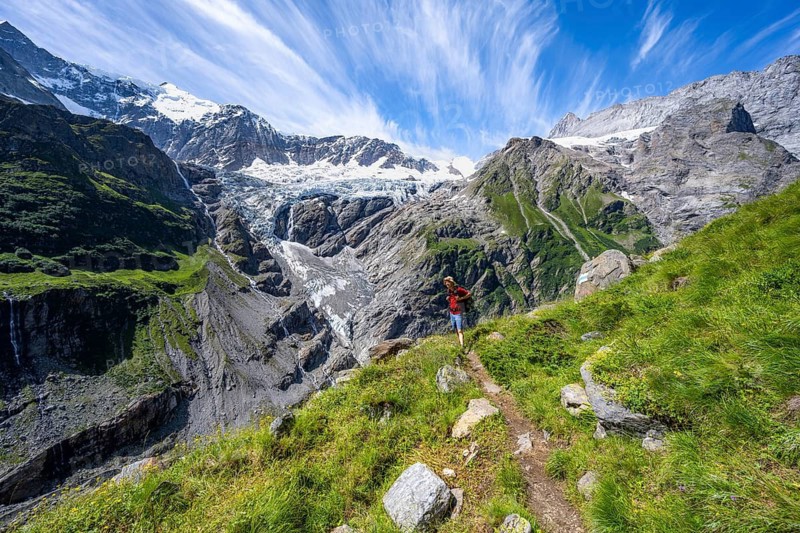 Mountaineers on hiking trail in front of mountain panorama, picturesque high alpine mountain landscape with Grindelwald-Fiescherfirn glacier, hike to Schreckhornhütte, Bernese Oberland, Switzerland