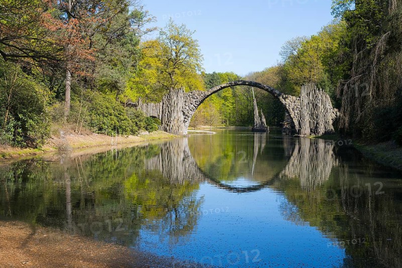 Stone bridge over calm water with perfect reflection in the surrounding forest, Rakotz Bridge, Devil's Bridge, Rakotzsee, arched bridge, reflection, basalt organ, Kromlau, Görlitz district, Saxony, Germany