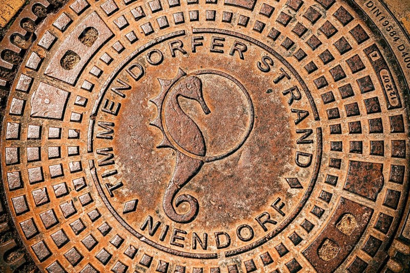Manhole cover with seahorse symbol in Timmendorfer Strand, Schleswig-Holstein, Germany +++ editorial use only