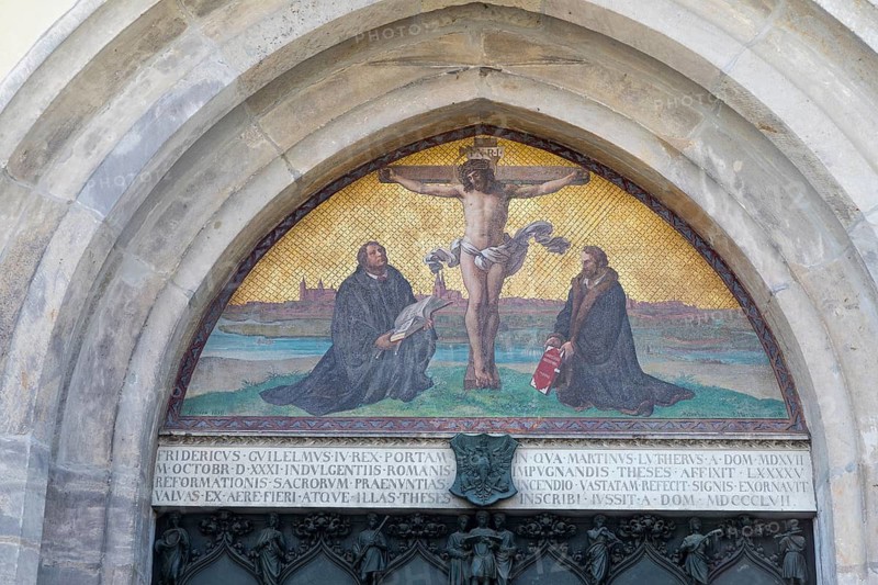 Mural above the thesis door at the castle church with Christ the Crucified, next to Martin Luther and Philipp Melanchthon, Luther city Wittenberg, Saxony-Anhalt, Germany