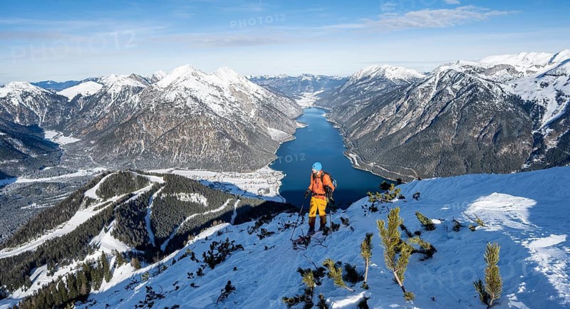 Picturesque view of Achensee and wintry mountain scenery, ski tourers climbing to Bärenkopf, Achensee, Tyrol, Austria
