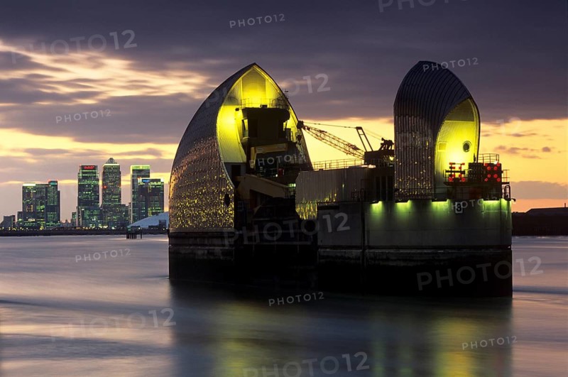 The Thames Barrier at dusk with Canary Wharf beyond, London, England, United Kingdom