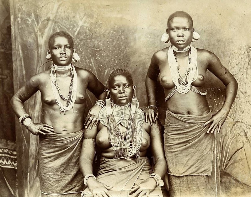 Africa, Zulu, South Africa, Three woman in traditional clothing and eye-catching jewelry pose for a portrait, around 1910