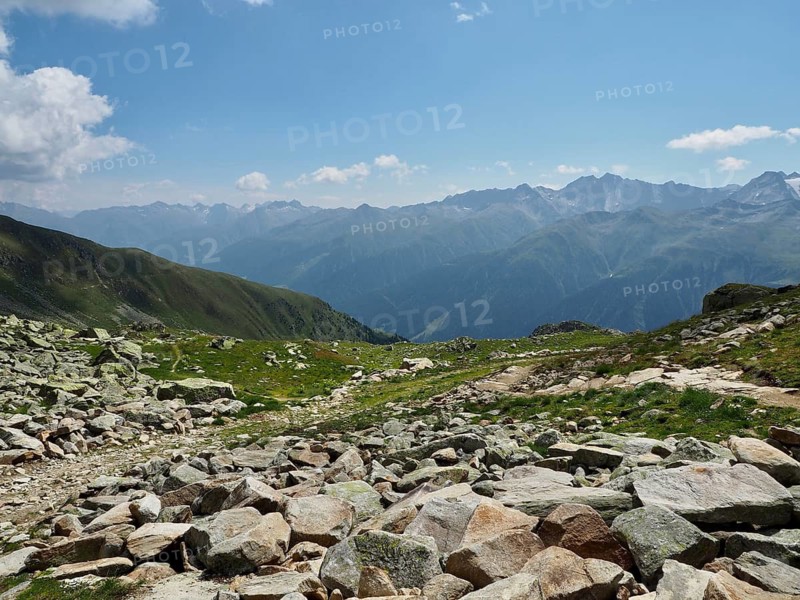 Rough, rocky terrain with a wide view over the Alps, blue sky with clouds, Bellwald, Goms, Canton of Valais, Switzerland