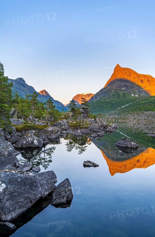 Picturesque mountain landscape in the Innerdalen high valley with Innerdalstårnet peak, mountain peaks reflected in Lake Innerdalsvatna, in the evening light at sunset, Trollheimen Mountain Area, Sunndal, Møre og Romsdal, Norway