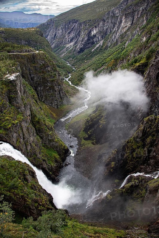 Majestic waterfall in a deep gorge with lush green landscape, Voringsfossen, with 165m drop, above the village of Eidfjord, Hardangerfjord, Norway, Scandinavia