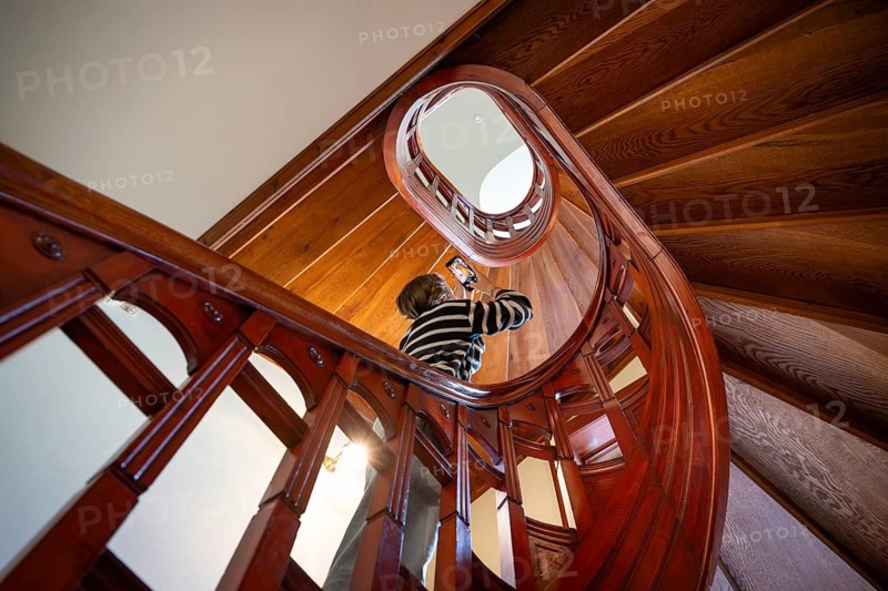 A visitor taking a photo with her mobile phone in the stairwell of the Art Nouveau-style Schwanenapotheke (Svaneapoteket), Museum Jugendstilsenteret og KUBE, Ålesund, Møre og Romsdal County, Norway