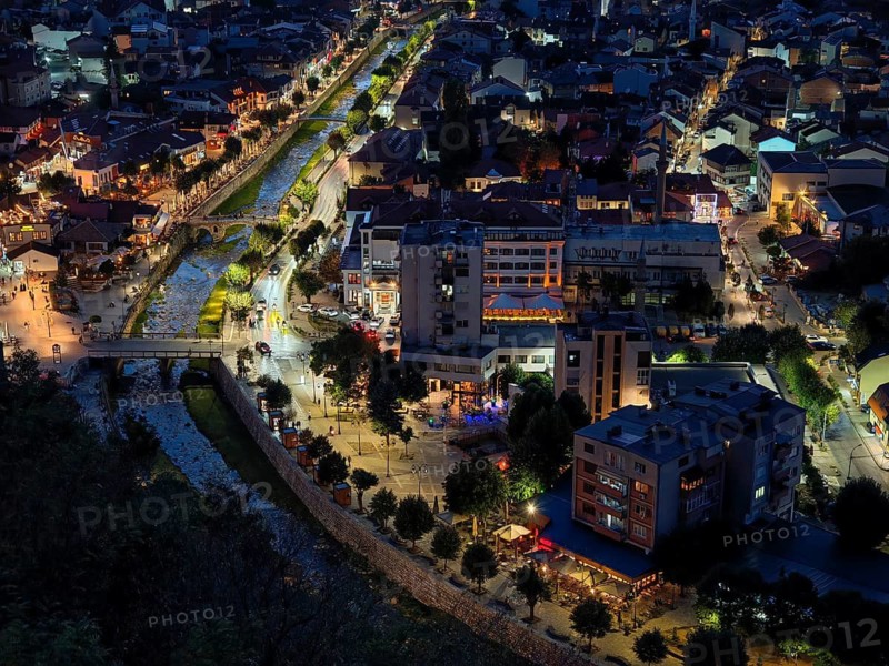 Night view of a city from above with illuminated river and busy streets, Prizren, Kosovo