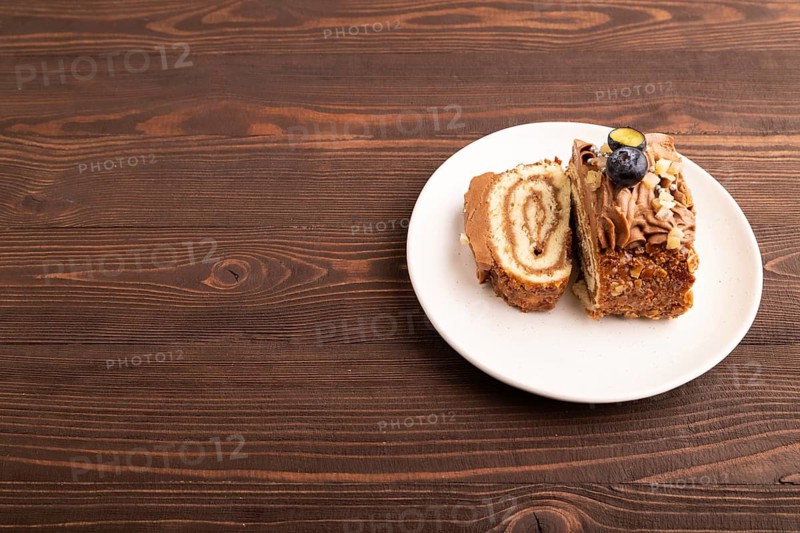Sweet loaf with cream and caramel on brown wooden background, copy space, side view
