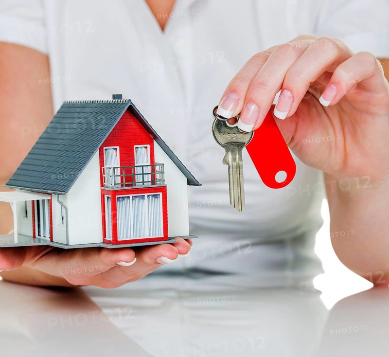 A real estate agent with a house and a key rental and house sale by real estate agent, apartment handover, house