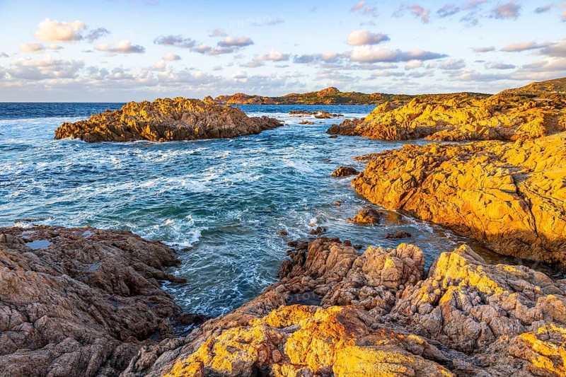 Landscape of the coastline with blue water at Marinedda Coast at sunset, Sardinia, Italy
