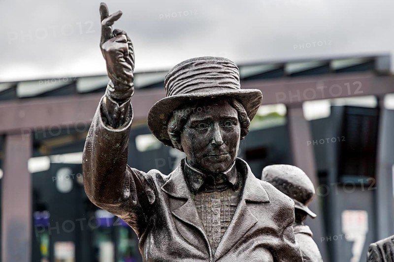 Close up detail of the bronze figure of Mary Barbour with raised hand, part of the rent strike monument at Govan Cross, Glasgow, Scotland, United Kingdom