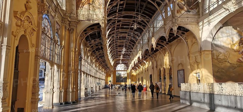 Historic arcades with frescoes where people walk along. Elegant ambiance, Maxim Gorky Kollonade, Marianske Lazne main collonade, Marianske Lazne, Czech Republic