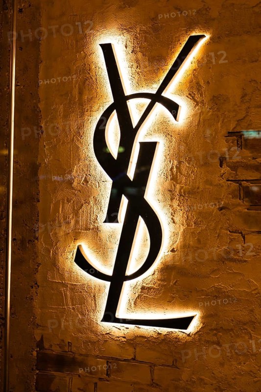 Vienna, Austria - 15 December, 2025: Illuminated YSL logo on a textured wall in Vienna, Austria. The logo is prominently displayed, showcasing the brands iconic design