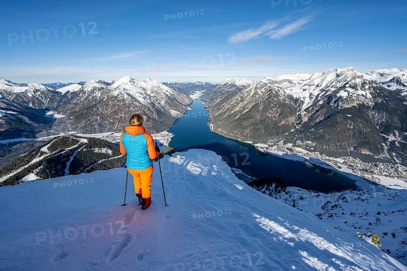 View of Achensee and wintry mountain scenery, ski tourer at the summit of Bärenkopf, Achensee, Tyrol, Austria