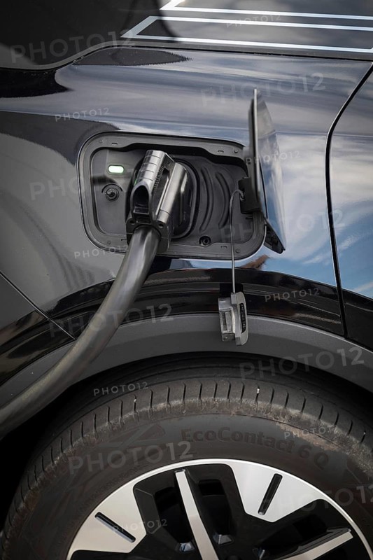 Fully electric Ford Explorer is being charged, charging cable in power tank, charging station for electric vehicles, Norway