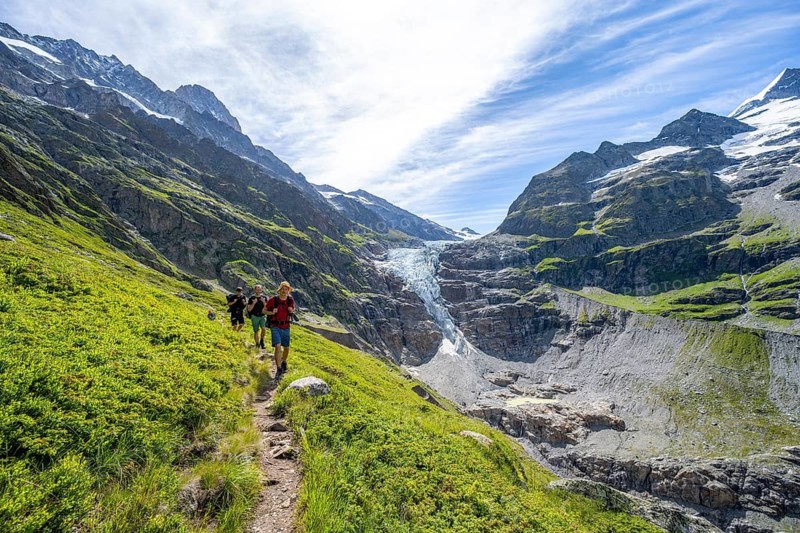 Mountaineers on hiking trail in front of mountain panorama, picturesque high-alpine mountain landscape with Lower Eismeer glacier range, hike to Schreckhornhütte, Bernese Oberland, Switzerland