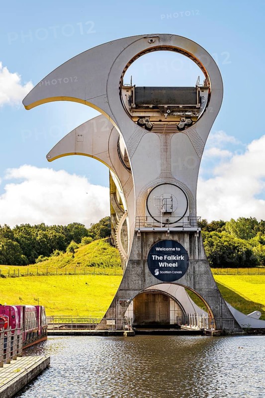 The Falkirk Wheel is the world's only rotating boat lift, connecting Scotland's Forth and Clyde Canal with the Union Canal. The wheel uses Archimedes' Principle to perfectly counterbalance two giant water-filled gondolas, allowing it to lift boats 24 metres in just five minutes, Tamfourhill, Falkirk, Scotland, United Kingdom