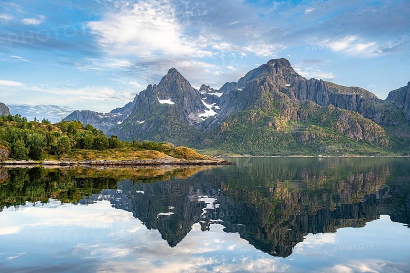 Mountains are reflected in the water in a bay on Raftsund fjord, Vesterålen, Norway