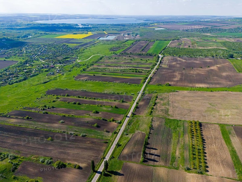 Green and brown fields with a long road in the middle in a wide rural area, aerial view, landscape near Braniste, Braniste, Hundred Hills Landscape Reserve, Rî?cani, Republic of Moldova, Moldova