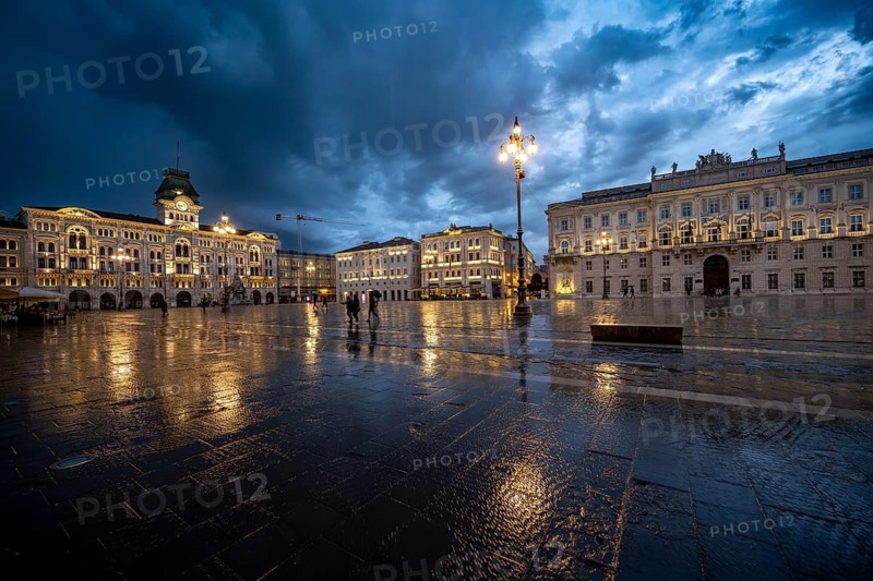 Illuminated square Piazza Unità d'Italia, City Hall, Palazzo Communale and Palazzo del Lloyd Triestino, with reflection, dramatic clouds, blue hour, old town, Trieste, Friuli-Venezia Giulia region, Italy