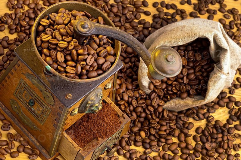Many coffee beans lie next to a coffee grinder. Freshly ground coffee, Austria