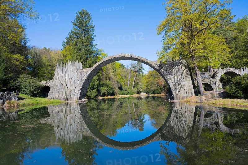 Perfect reflection of the stone bridge on the calm water, surrounded by forest, Rakotz Bridge, Devil's Bridge, Rakotzsee, arched bridge, reflection, basalt organ, Kromlau, Görlitz district, Saxony, Germany