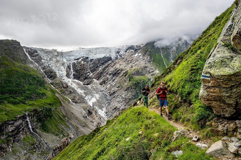 Mountaineers on a hiking trail, dramatic mountain landscape with Grindelwald-Fiescherfirn glacier, Bernese Alps, Bernese Oberland, Switzerland