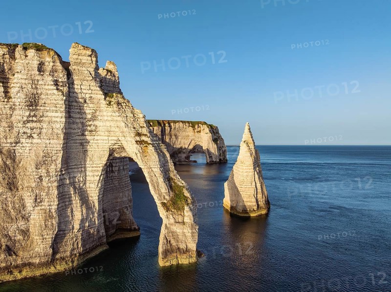 Aerial view of the Porte d'Aval rock formation with the free-standing Aiguille d'Étretat rock pin in the morning sun, well-known sights and natural beauty on the chalk coast with the distinctive rock pin, behind it the La Manneporte rock gate, Étretat, Alabaster Coast, La Côte d'Albâtre, chalk cliffs, English Channel, Seine-Maritime, Normandy, France